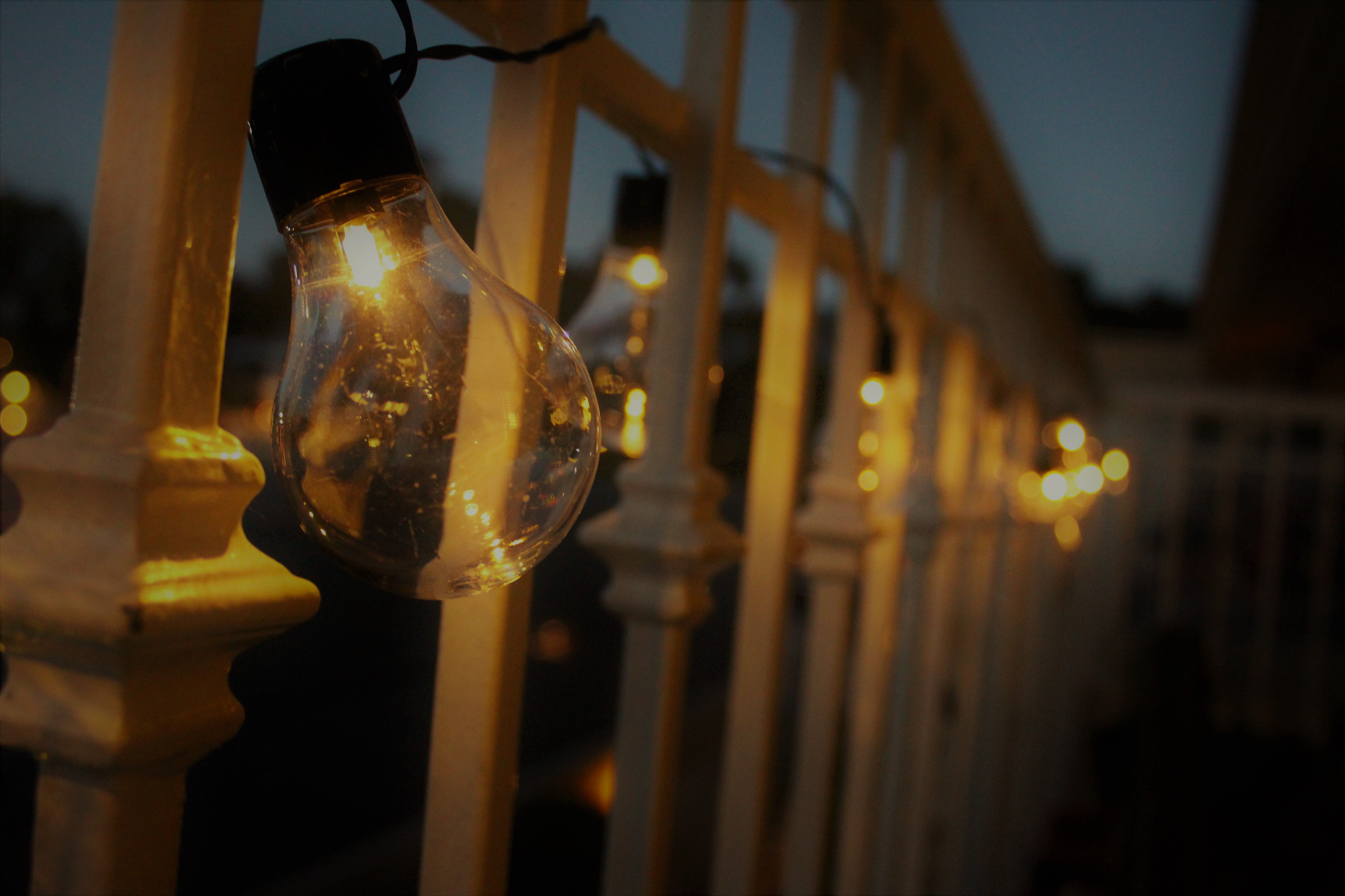 Warm glow from string lights hanging on a balcony railing at twilight